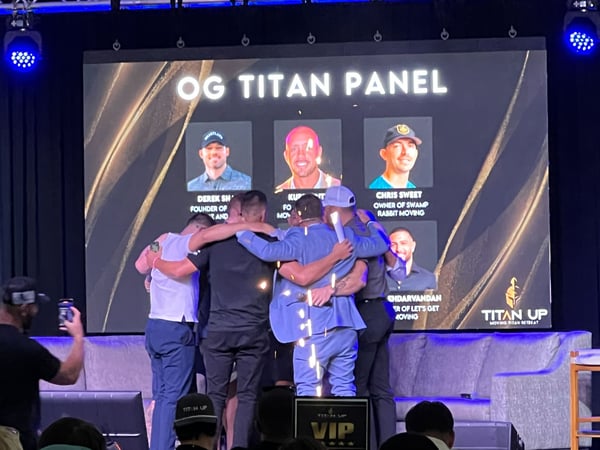 Moving Titan 2025 speakers on stage in a huddle